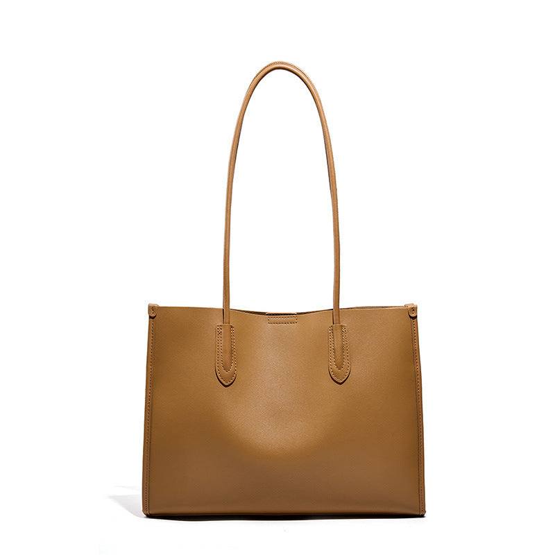 Tote leather bag in brown with minimalist design and reinforced straps.