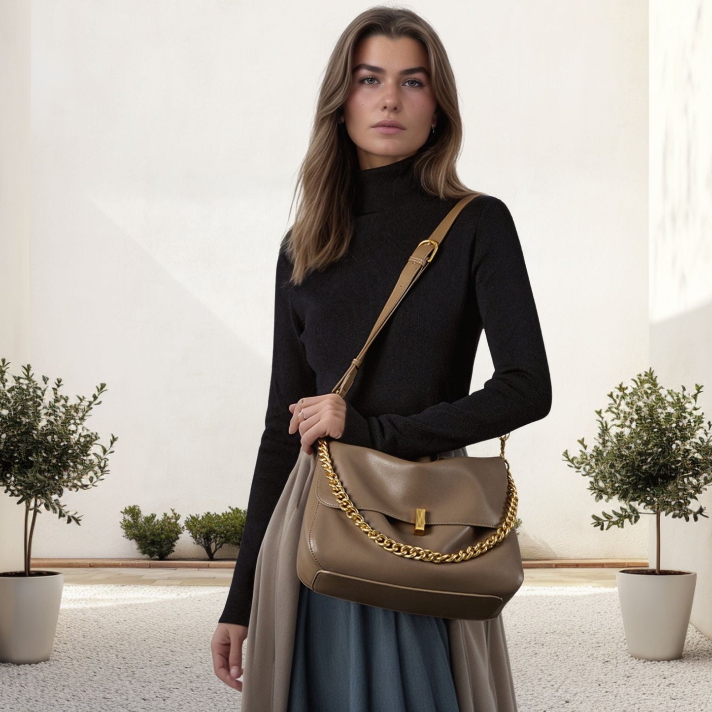Small messenger purse in genuine leather with chain strap, held by a woman in