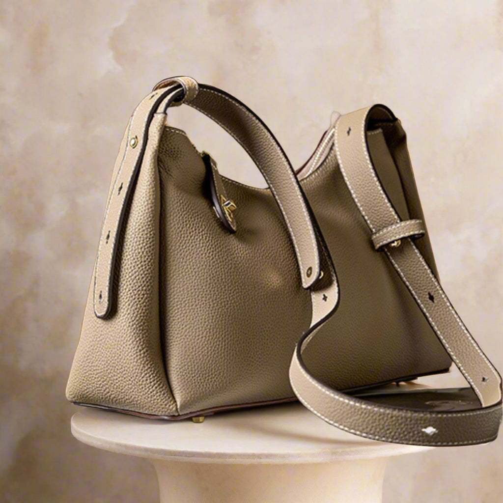 Trapezoid leather crossbody handbag with adjustable strap and lychee-patterned design.