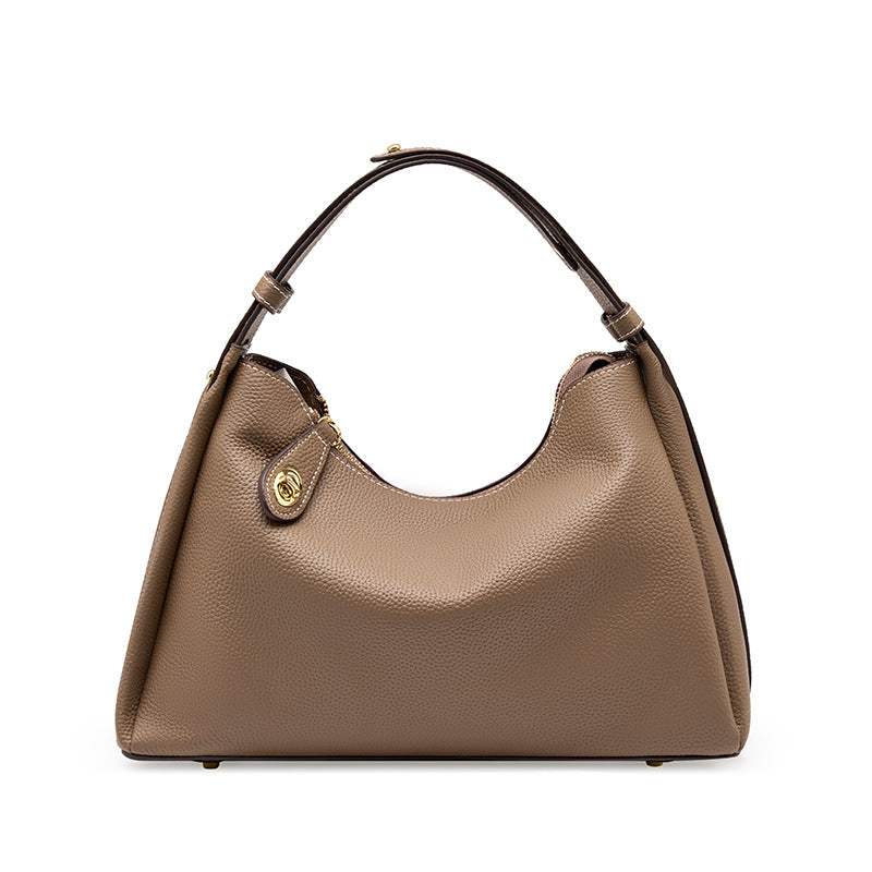 Trapezoid leather crossbody handbag with lychee-patterned texture and adjustable strap.