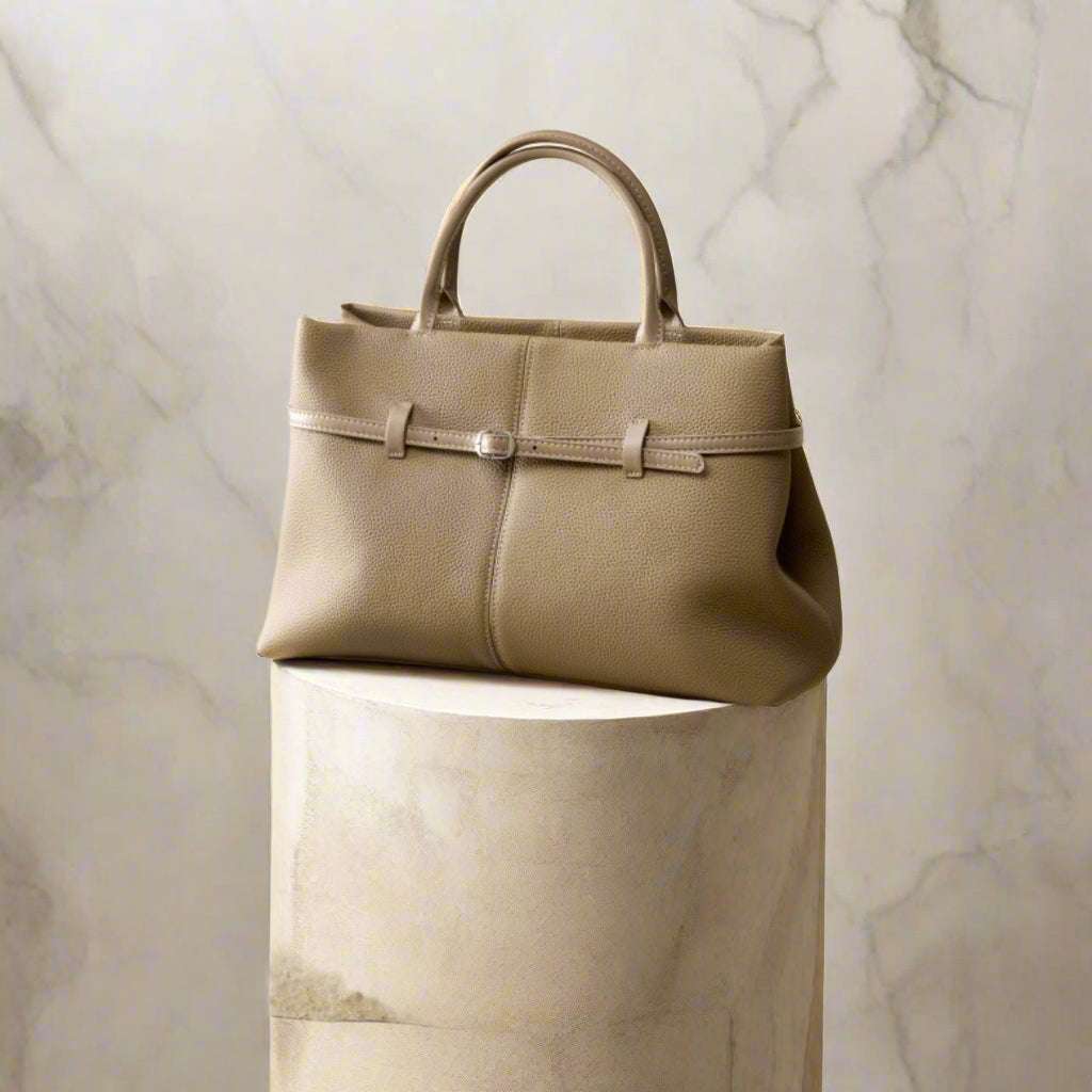Women's leather briefcase bag in elegant design, displayed on a stylish pedestal.