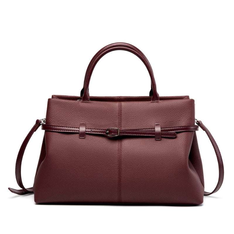 Women's leather briefcase bag in wine red with handles and adjustable strap.