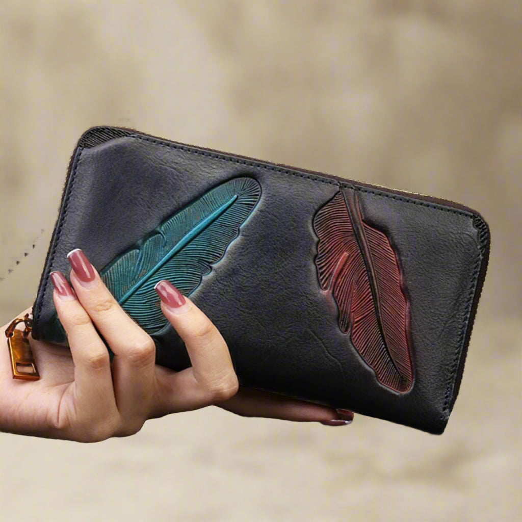 Hand holding black Leather Womens Leaf Wallet with embossed leaf design.
