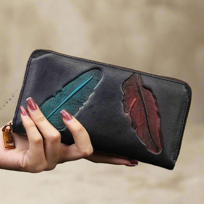 Hand holding black Leather Womens Leaf Wallet with embossed leaf design.