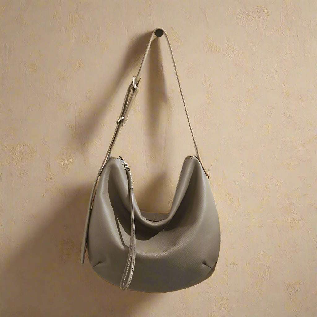 slouchy crossbody bag in genuine leather hanging on wall