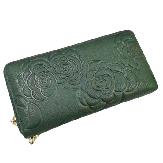 Green womens leather wallet with embossed floral design.