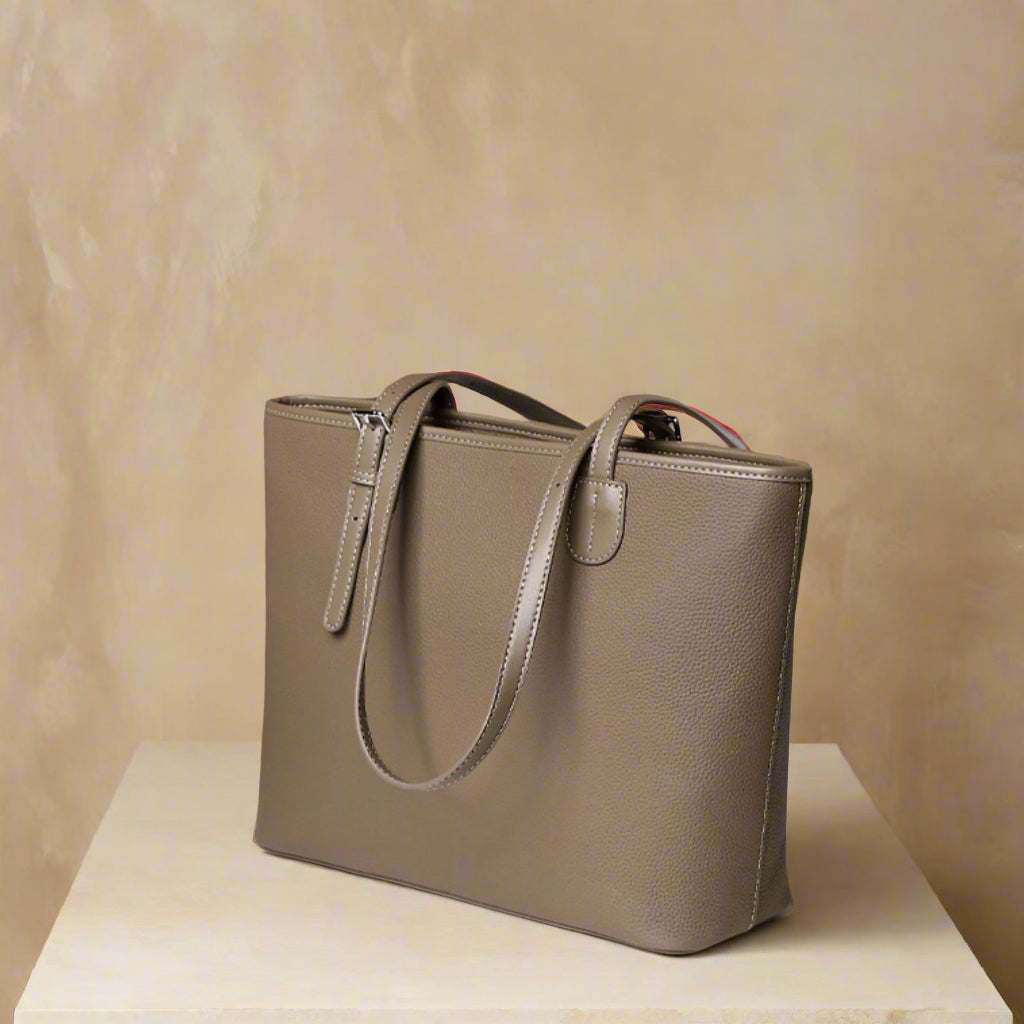 Gray zip tote bag made of leather with adjustable shoulder straps on