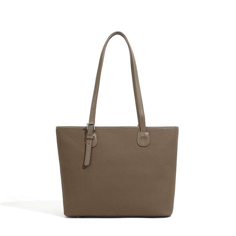 Two-tone leather zip tote bag with adjustable shoulder straps.