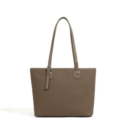 Two-tone leather zip tote bag with adjustable shoulder straps.