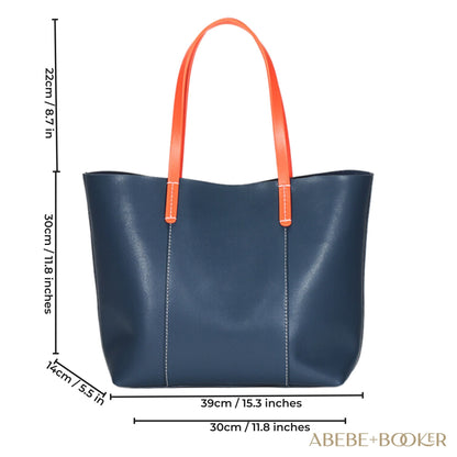Blue leather handbag with vibrant carrot-colored straps, features spacious interior with dedicated pockets, crafted from genuine leather for durability, part of the Essence of Elegance Collection.